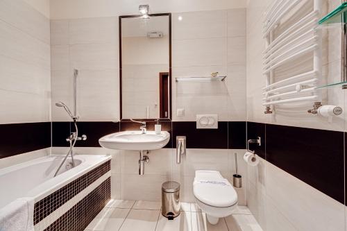 a bathroom with a sink and a toilet and a tub at Villa Porto in Pobierowo