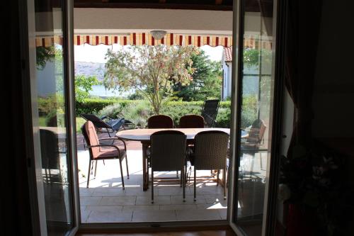 un tavolo e sedie su un patio con porta in vetro di Apartments Maria Rab a Barbat na Rabu