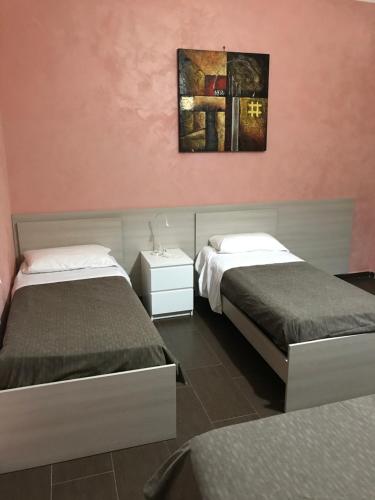a bedroom with two beds and a painting on the wall at Villa Scotillo Boutique Hotel in Agropoli