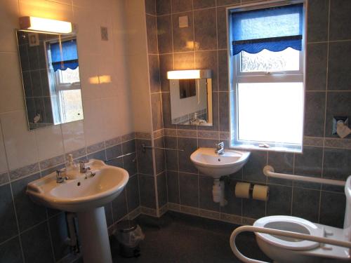 une salle de bain avec deux lavabos et un WC et une fenêtre dans l'établissement Colston Hall Cottages, à Framlingham