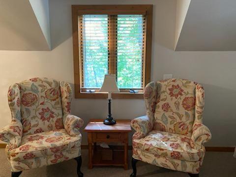 Habitación con 2 sillas y mesa con lámpara. en Lolly's Treehouse, en Highlands