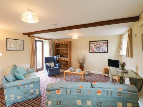 a living room with a couch and a table at The Linney in Northleigh