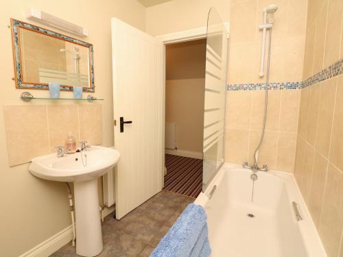 a bathroom with a sink and a toilet and a shower at The Linney in Northleigh