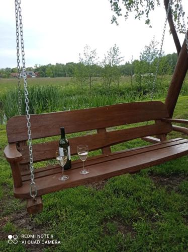 a swing with a bottle of wine and two glasses at Agroturystyka Pasynki 44 in Zabłudów
