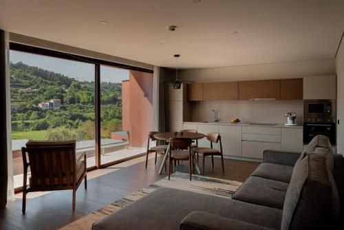 a living room with a couch and a table and a kitchen at Quinta de Santo António - Country House & Villas in Marco de Canaveses