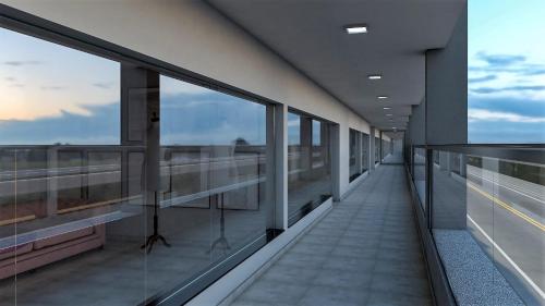 a corridor of an office building with glass windows at Jahu Center Plaza Flats in Jaú