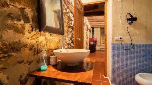 La salle de bains est pourvue d'un lavabo sur une table en bois. dans l'établissement El Cau dels Somnis, à La Cuevarruz