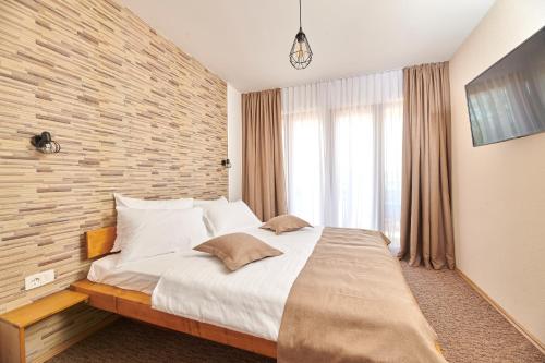 a bedroom with a large bed and a brick wall at Sobe Sole in Umag