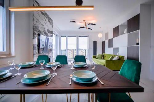 a dining room table with plates and silverware on it at CITYSTAY Dluga Grobla Gdansk Apartment with Sauna in Gdańsk