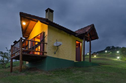 a small house with a porch and a balcony at Pousada Lua de Minas in Visconde De Maua
