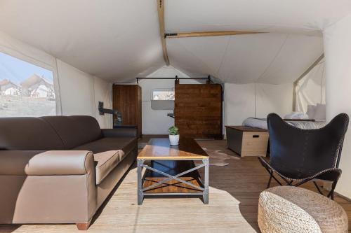 a living room with a couch and a table at Under Canvas Zion in Virgin