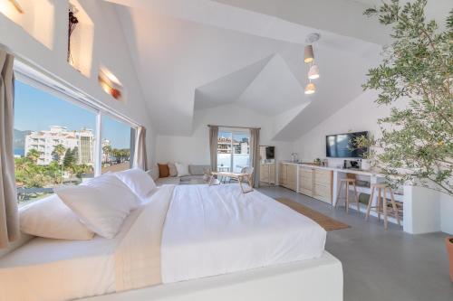 un grande letto bianco in una stanza con una grande finestra di L'olive homes a Marmaris