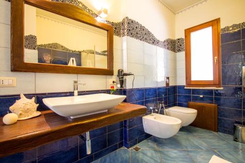 a bathroom with a sink and a toilet at Suites Voce del Mare in Tertenìa