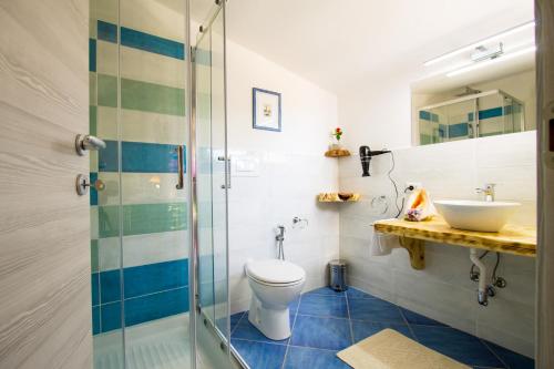 a bathroom with a toilet and a sink at Suites Voce del Mare in Tertenìa