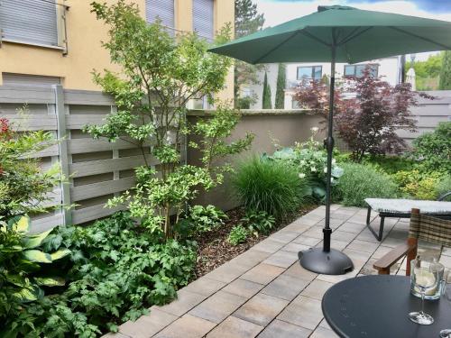 a patio with a table and an umbrella at Weinreisedomizil mit eigenem Garten und Parkplatz in Deidesheim