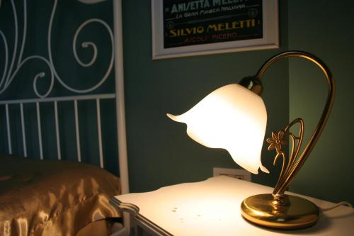a lamp sitting on a table next to a bed at Il Nido del Picchio in Ascoli Piceno