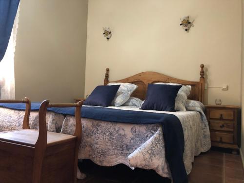 a bedroom with two beds and a chair at Casa Rural El Infante in Oropesa