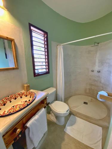 a bathroom with a toilet a sink and a shower at Casa Cacahuate Holbox-Casa entera con jardin-Whole house with garden in Holbox Island