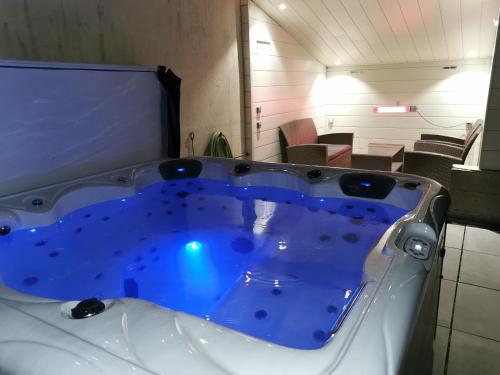 a large jacuzzi tub in a room with chairs at Ô Rethel Jacuzzi, Gîte Ardennes in Rethel