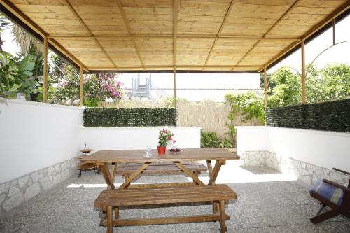 a patio with a wooden table and benches at Villa Latino in Vieste