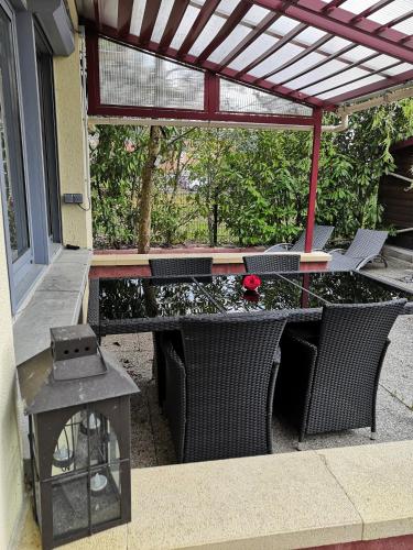 a patio with a table and chairs under a pergola at Ô Rethel Jacuzzi, Gîte Ardennes in Rethel