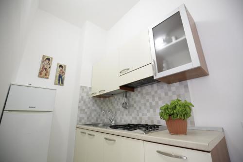 a kitchen with a sink and a stove and a refrigerator at Villa Latino in Vieste