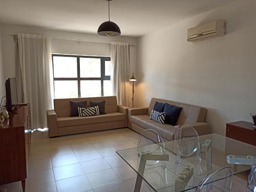 a living room with a couch and a glass table at ACC Apartamento T1 Palmela Village in Palmela