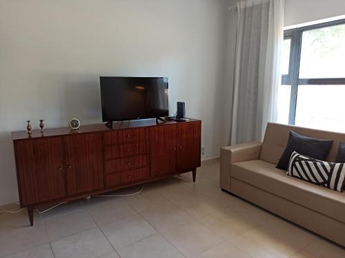 a living room with a couch and a flat screen tv at ACC Apartamento T1 Palmela Village in Palmela