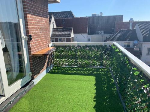 a garden on a balcony with green grass at Mylos Studios in Alkmaar