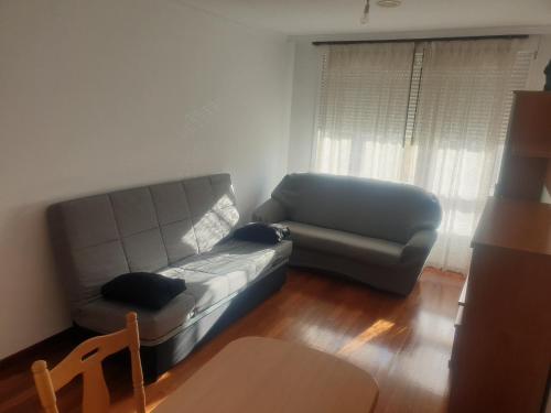 a living room with a couch and a chair at Alquiler Vacacional Noia in Noya