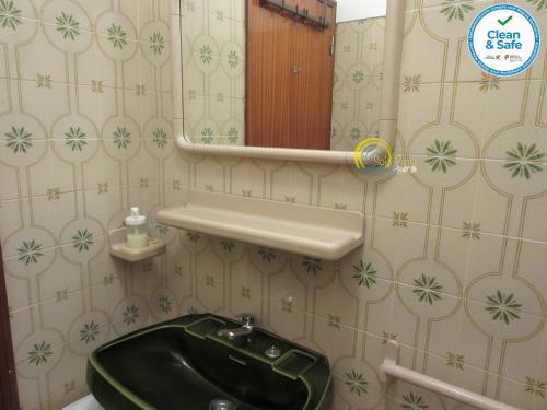 baño con lavabo verde y espejo en Sol e Praia - Peniche II, en Peniche