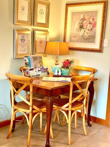a wooden table with two chairs and a lamp at Ah House City B&B Nelson in Nelson