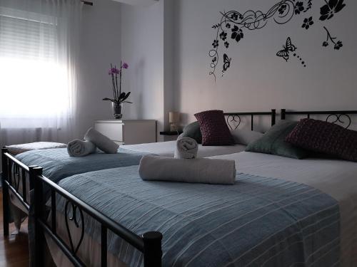 um quarto com duas camas com almofadas em Rúa dos Concheiros, 7 Apartamento em Santiago de Compostela