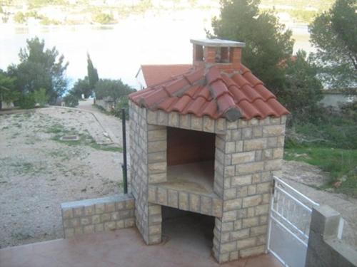 a brick oven with a red roof on a patio at Apartment in Grebaštica with sea view, balcony, air conditioning, WiFi (3571-3) in Grebaštica