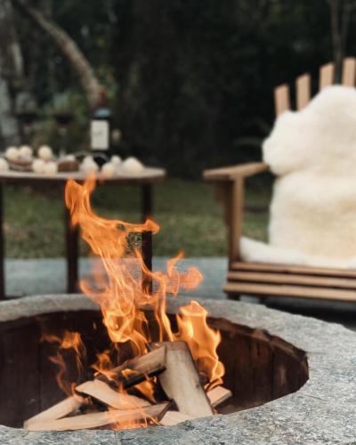 a fire pit with flames in it in a yard at Hotel Pousada 7 Mares in Itapema