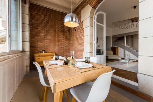 une salle à manger avec une table en bois et des chaises blanches dans l'établissement COAST KEYWEEK Duplex apartment in the city center with sea view, à Biarritz