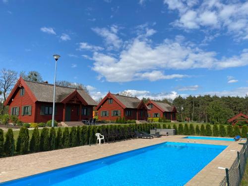 a house with a swimming pool in front of a house at Brzezina Resort - Wille in Żnin