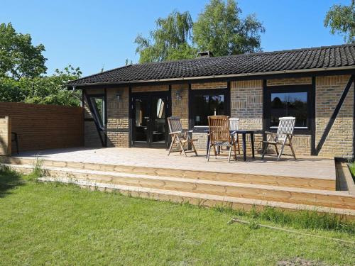 a patio with chairs and a table in front of a building at Charming Harbor Cottage-By Traum in Jægerspris