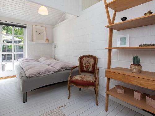 een slaapkamer met een bed, een stoel en een bureau bij Holiday home Strøby VIII in Strøby