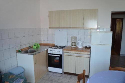 eine kleine Küche mit einem Herd und einem Kühlschrank in der Unterkunft Apartment in Lun with sea view, terrace, air conditioning, Wi-Fi (4829-1) in Lun