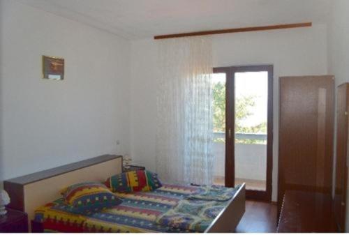 Schlafzimmer mit einem Bett und einer Glasschiebetür in der Unterkunft Apartment in Lun with sea view, terrace, air conditioning, Wi-Fi (4829-1) in Lun