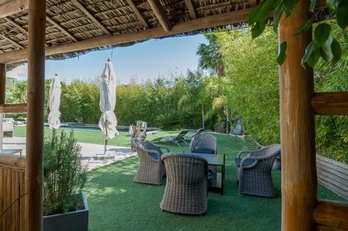 une terrasse avec des chaises, une table et des parasols dans l'établissement Villa in Juan-Les-pins with heated pool, à Antibes
