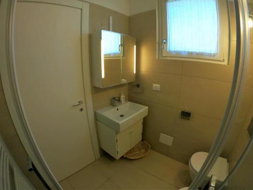 a bathroom with a sink and a toilet and a window at Orchidea Beach in Civitanova Marche