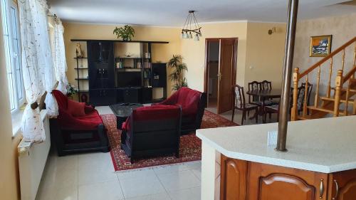 uma sala de estar com cadeiras vermelhas e uma mesa em Domy nad jeziorem em Bogaczewo