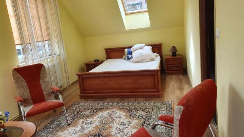 a bedroom with a bed and two chairs and a rug at Domy nad jeziorem in Bogaczewo