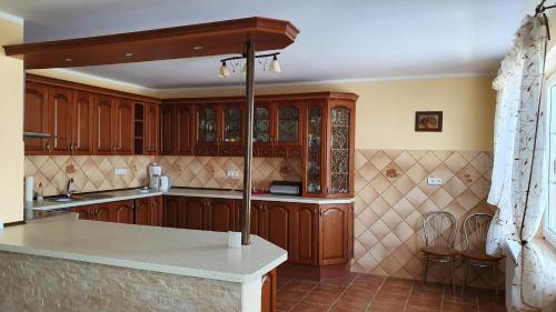 uma cozinha com armários de madeira e uma bancada em Domy nad jeziorem em Bogaczewo