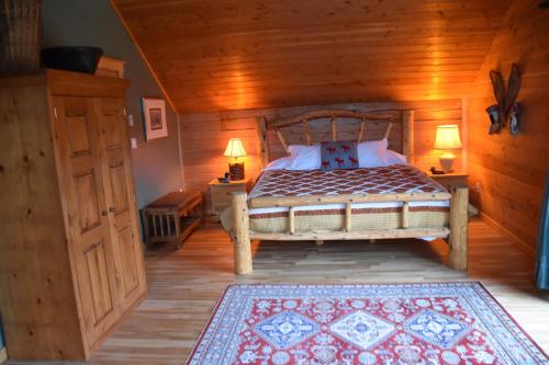 a bedroom with a bed and two lamps in a room at Seven Sisters Mountains House in Kitwanga