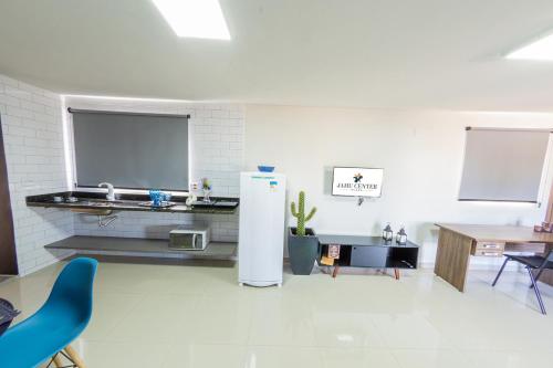 a white room with a refrigerator and a table at Jahu Center Plaza Flats in Jaú