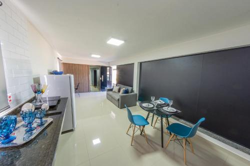 a kitchen with a table and chairs and a refrigerator at Jahu Center Plaza Flats in Jaú