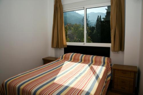 1 dormitorio con cama y ventana en Alojamientos Madrigal, en Cazorla